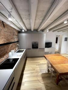 a kitchen with a wooden table and a wooden table sidx sidx sidx at Antico Rudere Luxury Apartment in Chioggia