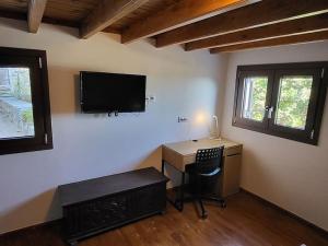 a room with a desk and a television on the wall at Saint George House in Ierapetra