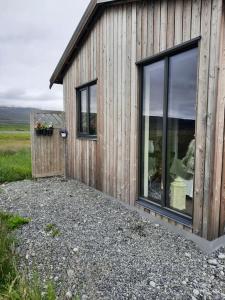 um pequeno edifício de madeira com uma janela num campo em Stóri-Bakki cosy cottage near Egilsstaðir-Jökull em Stóri-Bakki