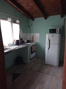 a kitchen with a white refrigerator and a window at "Donde brilla el sol" Casa Campo in Dina Huapi +1 photo