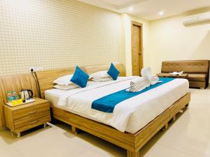 a bedroom with a large bed with blue pillows at The Landmark Banjara Hills - Hyderabad in Hyderabad