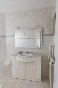 Baño blanco con lavabo y espejo en Quinta do Retiro en Felgar