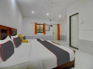 a bedroom with a large bed and a yellow chair at Homely Stays Resort in Pune