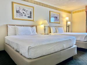 a hotel room with two beds with white pillows at Brentwood Inn & Garden in Farmington