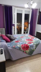 1 dormitorio con 1 cama con edredón de flores en Departamento Plaza Colón, Mar del Plata en Mar del Plata