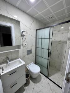 een badkamer met een toilet, een wastafel en een douche bij Mira Suite Apart in Trabzon
