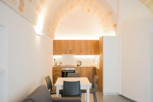 a kitchen and dining room with a table and chairs at Suite Polignani by STHEY in Monopoli