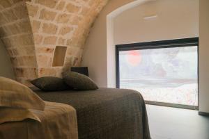 a bedroom with a bed and a large window at Suite Polignani by STHEY in Monopoli