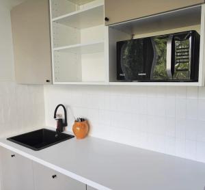 a white kitchen with a sink and a microwave at Näsinkulma Aprt with Sauna, Free 5G Wifi, Downtown in Tampere
