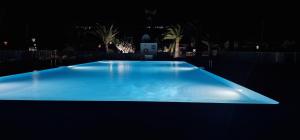 una gran piscina azul iluminada por la noche en Casa De Nefertiti, en Playa Blanca