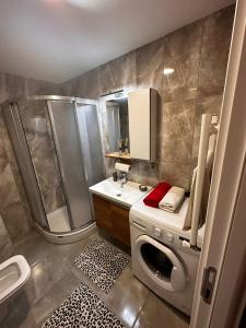 een badkamer met een douche en een wasmachine bij Kagıthane Gulmahal Residance 1+1 in Istanbul