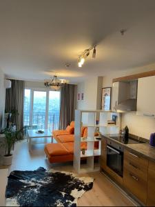 een keuken en een woonkamer met een oranje bank bij Kagıthane Gulmahal Residance 1+1 in Istanbul