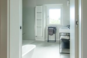 uma casa de banho branca com uma banheira e um lavatório em Style apartments VdA em Senin