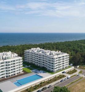 widok z powietrza na dwa duże białe budynki i ocean w obiekcie Sunrise Apartament w Rogowie