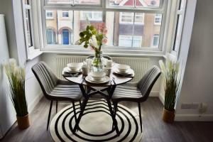 a dining room table with chairs and a vase of flowers at Seaside Flat, Contractors, Family, Business, Parking in Portslade