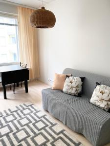a living room with a couch and a piano at PEURANIITTY 3 - Modern easygoing apartment in Espoo