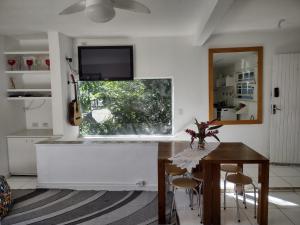 a kitchen with a table and a television on the wall at O melhor por do sol de Paúba! Casa Aconchegante. in São Sebastião +28 photos