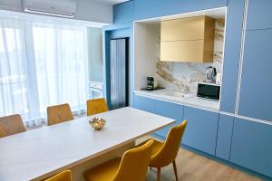 a kitchen with blue cabinets and a table and chairs at Unique Sea View Infinity Pool & Spa in Mamaia Nord