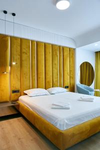a bedroom with a large bed with a wooden wall at Unique Sea View Infinity Pool & Spa in Mamaia Nord