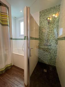 La salle de bains est pourvue d'une douche avec une porte en verre. dans l'établissement Nice house with garden near the sea, à Brem-sur-Mer