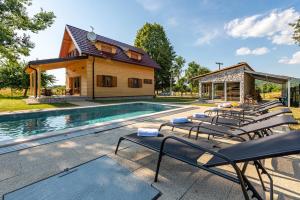 a group of lounge chairs next to a swimming pool at Vila Lipa in Ličko Cerje