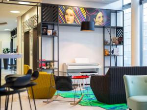 een kamer met stoelen, een tafel en een piano bij Aparthotel Adagio Köln City in Keulen