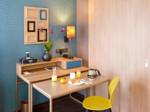 a room with a desk and a yellow chair at Aparthotel Adagio Köln City in Cologne