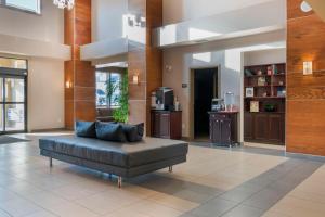 a living room with a black couch in a building at Best Western Plus Moose Jaw in Moose Jaw