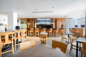 a restaurant with wooden tables and chairs and a bar at One Saltillo Aeropuerto in Saltillo