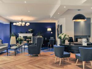 un salon avec des murs bleus et un piano dans l'établissement Mercure Paris Saint Cloud Hippodrome, à Saint-Cloud