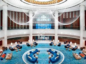 a large lobby with blue furniture and a domed ceiling at Fairmont Ajman in Ajman 