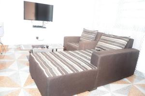 a living room with a couch and a tv at LES RÉSIDENCES SOHA in Cotonou