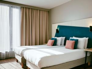 een slaapkamer met een groot bed met een blauw hoofdeinde bij Aparthotel Adagio Glasgow Central in Glasgow