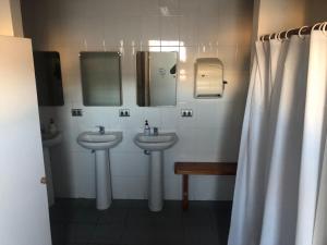 - Baño con 2 lavabos y 2 espejos en Hostel Huepil, en Pucón