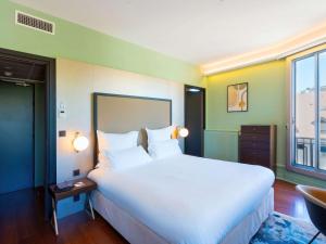 - une chambre avec un grand lit blanc et une fenêtre dans l'établissement Le Splendid Hotel Lac D'Annecy - Handwritten Collection, à Annecy