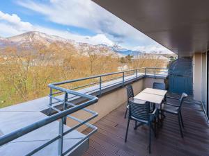 a balcony with a table and chairs and mountains at Le Splendid Hotel Lac D'Annecy - Handwritten Collection in Annecy