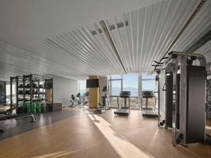 a gym with tread machines and a large window at Hilton Garden Inn Beijing Haidian Daoxiang Lake in Beijing