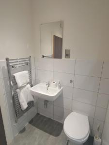 a white bathroom with a toilet and a sink at The Loft in Bradford