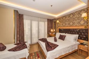 A bed or beds in a room at Aprilis Gold Hotel - Special Category