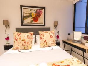 1 dormitorio con 1 cama y una pintura en la pared en Flamingo Sea Point Sea View Luxury Best Position 1 Bedroom Apartment Queen Size Bed & Inverter For TV, en Ciudad del Cabo