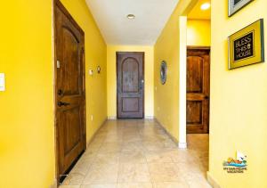 a hallway with yellow walls and a wooden door at Upscale San Felipe Vacation Villa 41-1 in Playa El Paraíso