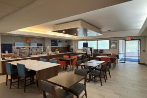 a restaurant with tables and chairs in a cafeteria at Holiday Inn Express Harrisburg NE, an IHG Hotel in Manadahill