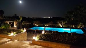 a swimming pool at night with lights at Retiro da Janela in Boliqueime