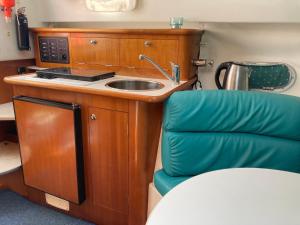 een keuken met een wastafel en een groene stoel bij Bateau Nirvana 7,6 m in Beaulieu-sur-Mer