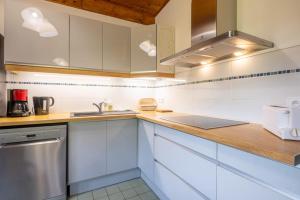 une cuisine avec des placards blancs et un comptoir en bois dans l'établissement Rustic chalet with garden in Chamonix, à Chamonix-Mont-Blanc
