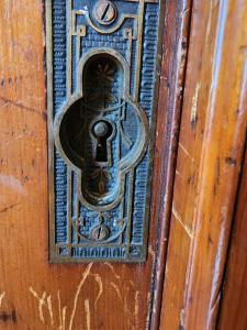 a metal door knocker on a wooden door at Cozy Victorian w/4-Car Garage! in Omaha