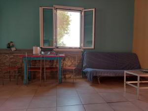 Zimmer mit einem Tisch, einem Sofa und einem Fenster in der Unterkunft Paradise lost in Kalamata