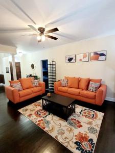 a living room with two orange couches and a table at The Elizabeth in Columbia
