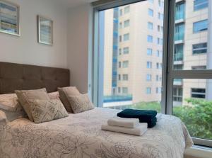 a bed with towels on it in front of a window at Luxury 1 Bed Apt - City Suites Ocean Spa Plaza in Gibraltar