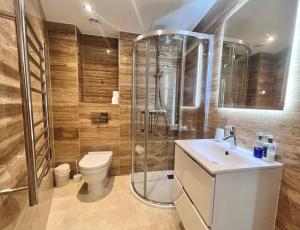 y baño con ducha, aseo y lavamanos. en Luxury 1 Bed Apt - City Suites Ocean Spa Plaza en Gibraltar